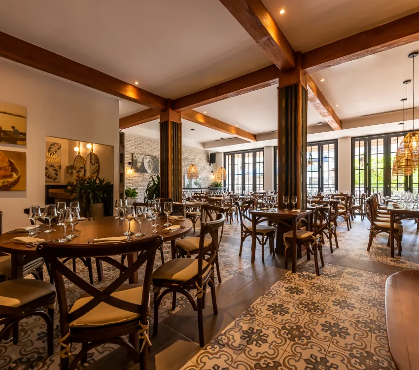 Comedor de restaurante elegante con mesas de madera y luz c&aacute;lida.