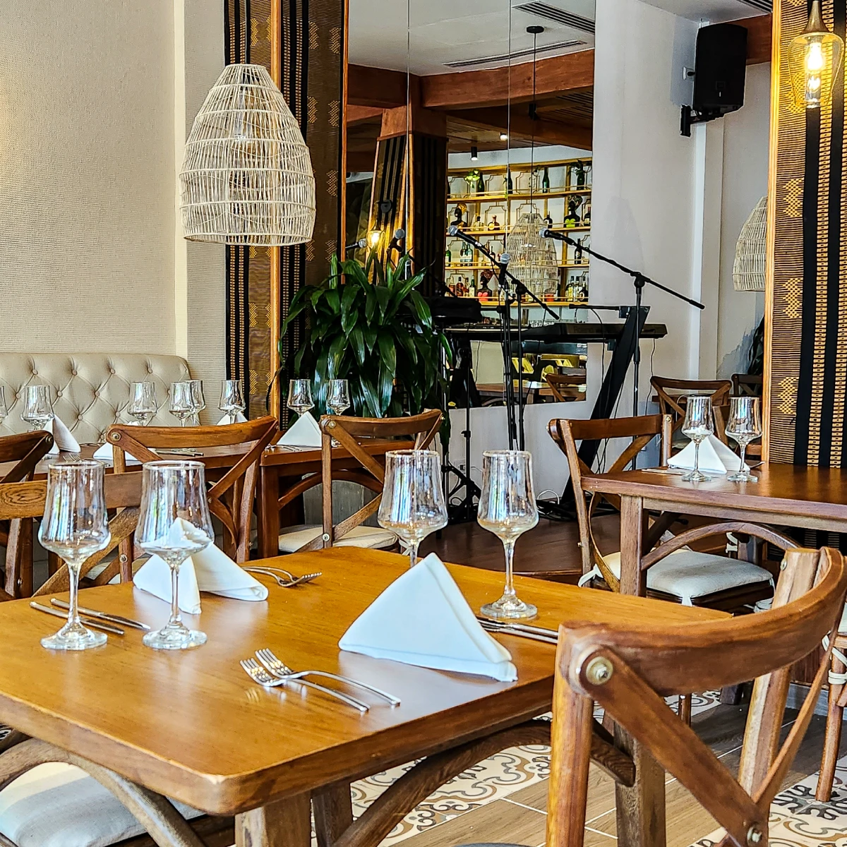 Restaurante elegante con mesas de madera y copas listas para cena.
