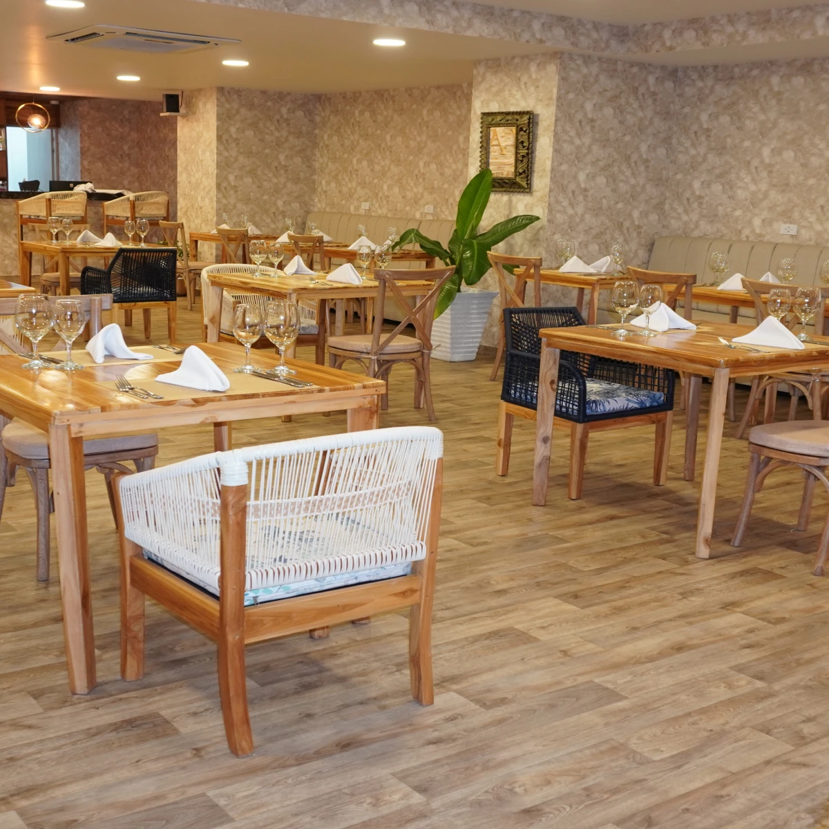 Restaurante elegante con mesas de madera y sillas tejidas.