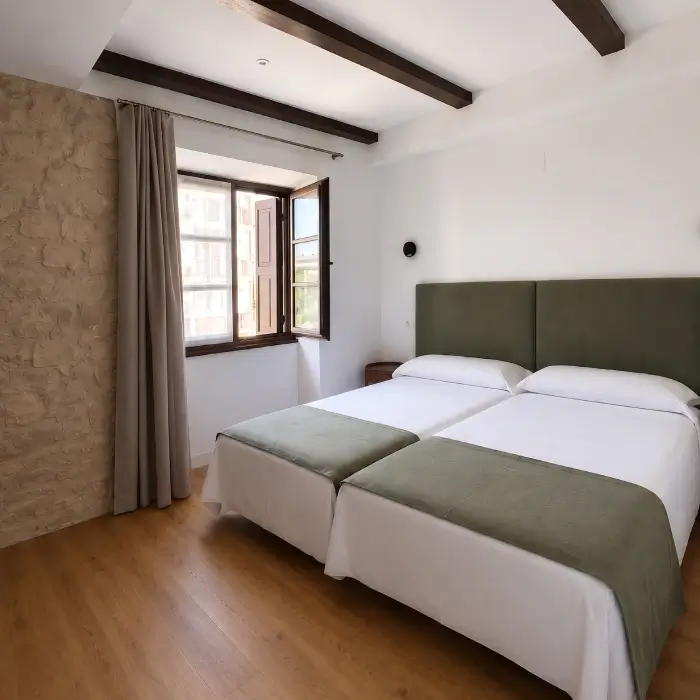 Dormitorio moderno con cama doble, cortinas grises y ventana abierta