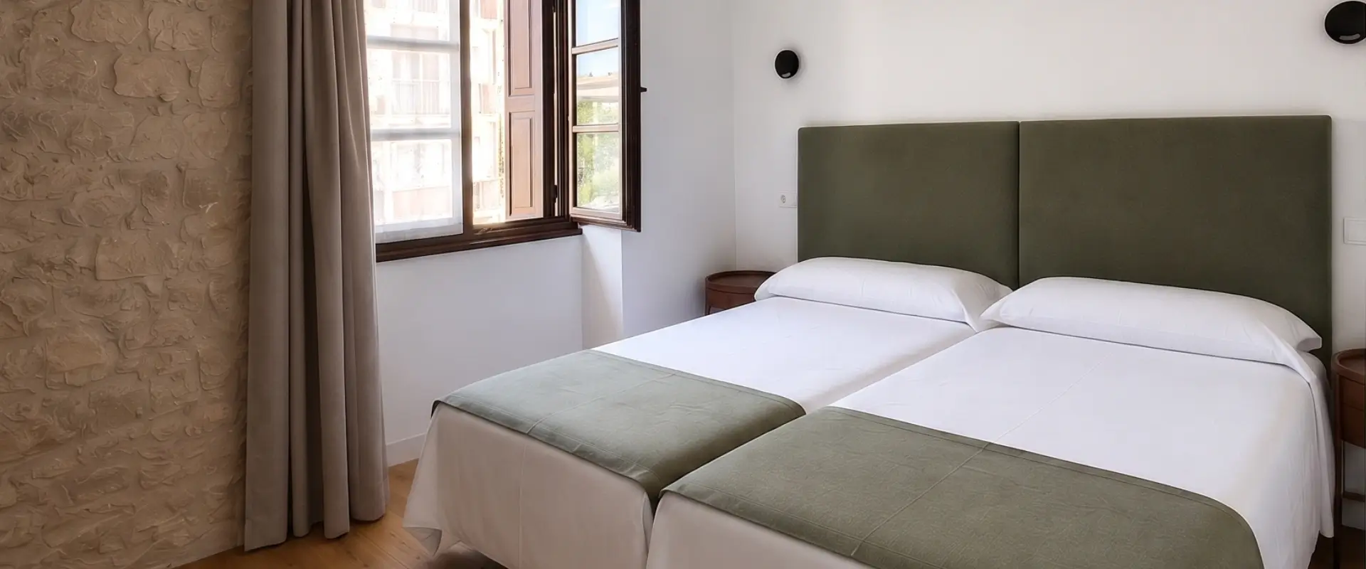 Dormitorio moderno con cama doble y ventanales, cortinas y cabecero verde