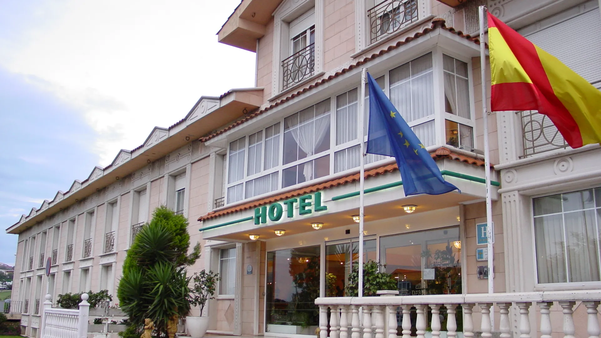 Fachada de un hotel con banderas de Europa y Espa&ntilde;a ondeando.