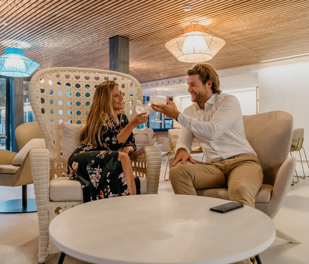 Personas brindando en un elegante sal&oacute;n con luz c&aacute;lida.