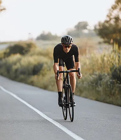 Persona en bicicleta de carretera en un camino rural.