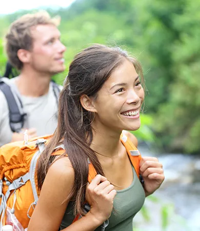 Personas sonrientes caminando por el bosque.