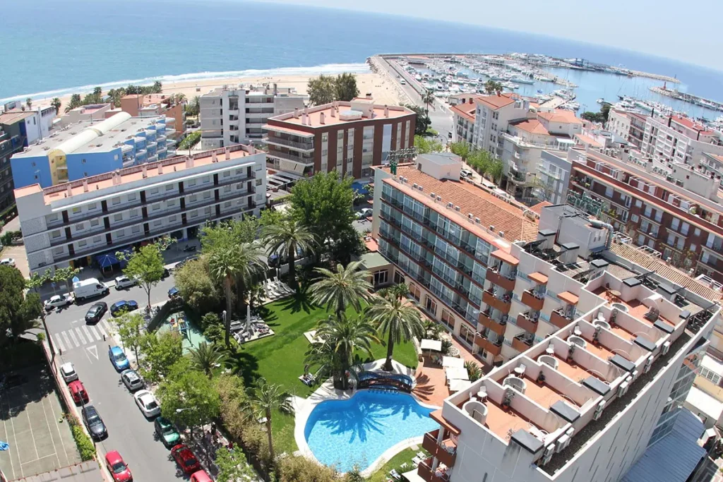 Vista a&eacute;rea de un complejo de edificios con piscina cerca del mar.