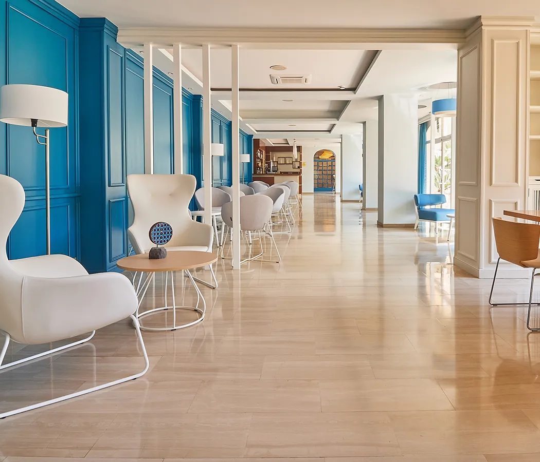 Sala moderna con sillas blancas y pared azul.