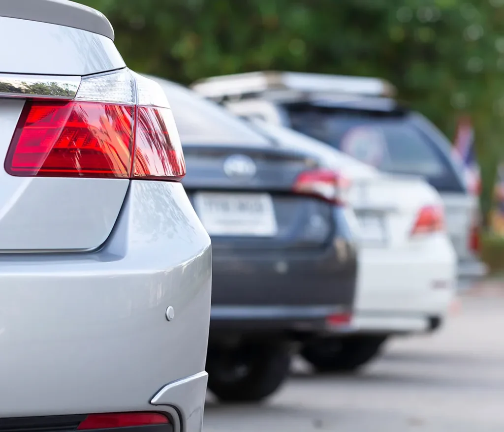 Autos estacionados en fila, enfocados en la parte trasera izquierda.