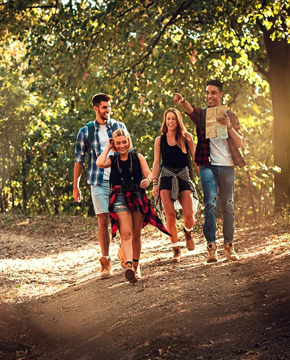 Grupo de amigos caminando por un sendero en el bosque.