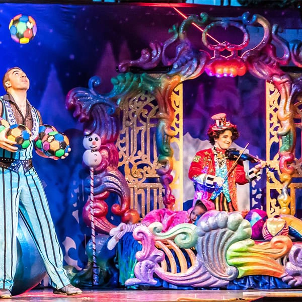 Artistas de circo: um malabarista e um violinista em um cen&aacute;rio colorido.