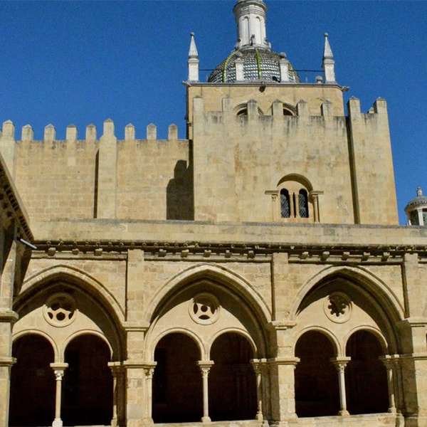 Antiga catedral com arcos e torre central, arquitetura hist&oacute;rica em pedra.