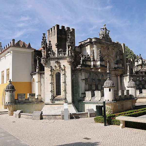 Edifica&ccedil;&atilde;o hist&oacute;rica com detalhes arquitet&ocirc;nicos ornamentados sobre c&eacute;u azul.