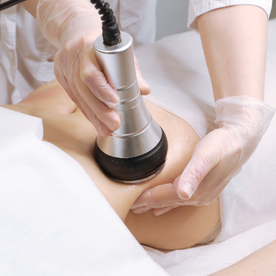 Profesional aplica tratamiento estético en el abdomen con dispositivo especial.