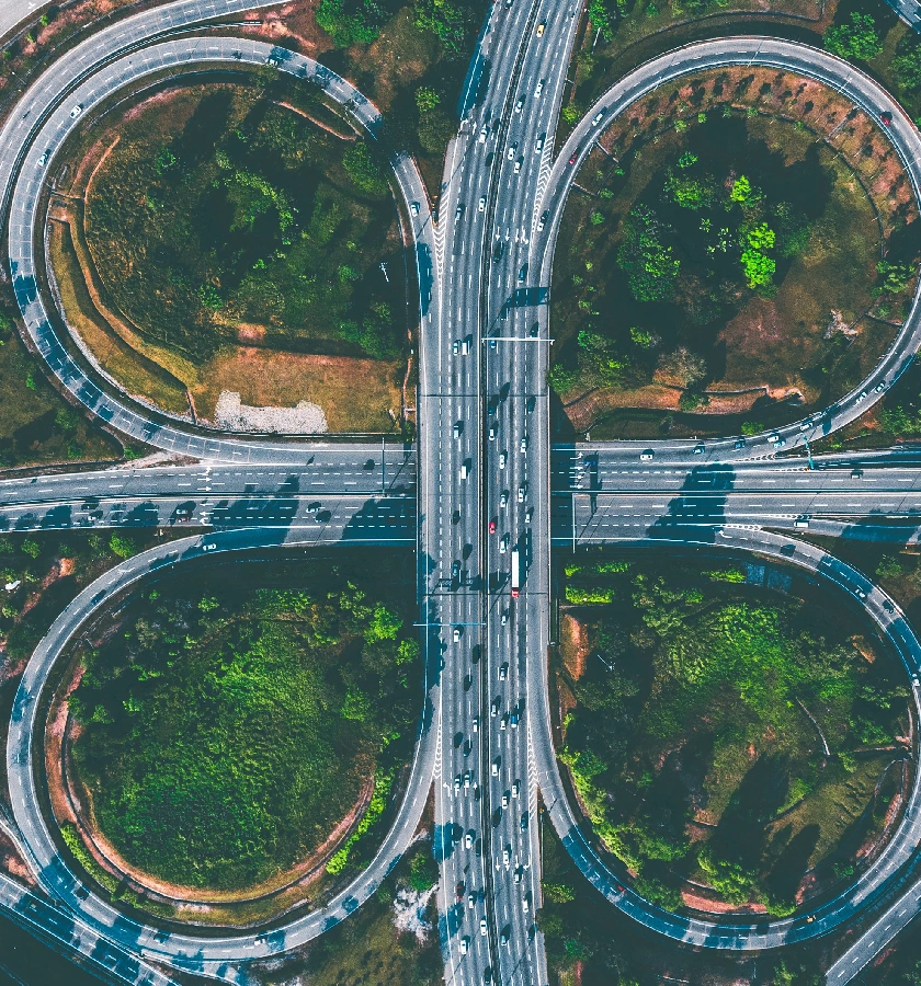 Encrucijada de autopistas rodeada de vegetaci&oacute;n desde arriba.