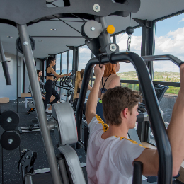 Personas haciendo ejercicio en un gimnasio con vista panor&aacute;mica.