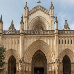Fachada de catedral g&oacute;tica con arcos y detalles ornamentales.