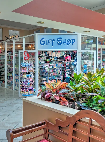 Tienda de regalos "Gify Shop" con entrada colorida y plantas al frente.