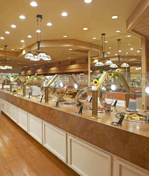 Buffet de comida con platos y decoraci&oacute;n luminosa en un restaurante elegante.