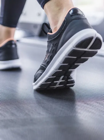 Zapatillas negras sobre una caminadora en uso.