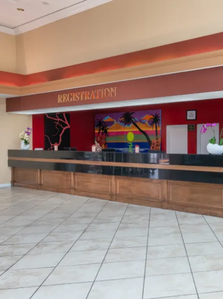 Mostrador de registro con decoraci&oacute;n tropical y orqu&iacute;deas. Piso de baldosas blancas.