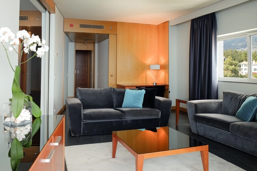 Modern living room with two gray sofas, coffee table, and a large window.