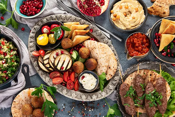 Assorted Mediterranean dishes with pita, falafel, and grilled vegetables.