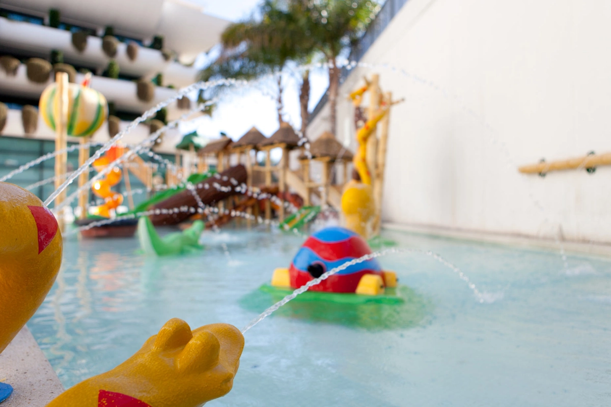 Parque acu&aacute;tico infantil con figuras coloridas y chorros de agua.