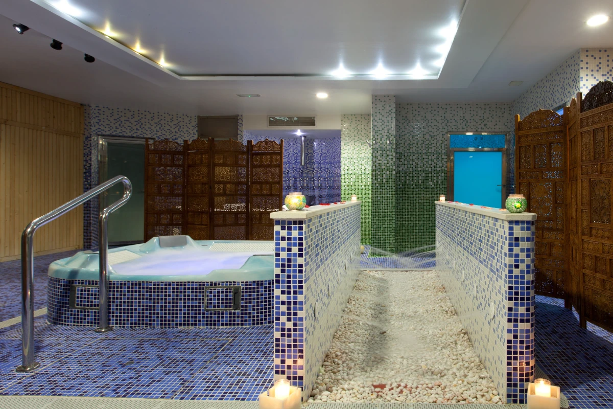 Spa con jacuzzi, caminito de piedras y luces c&aacute;lidas en un ambiente relajante.