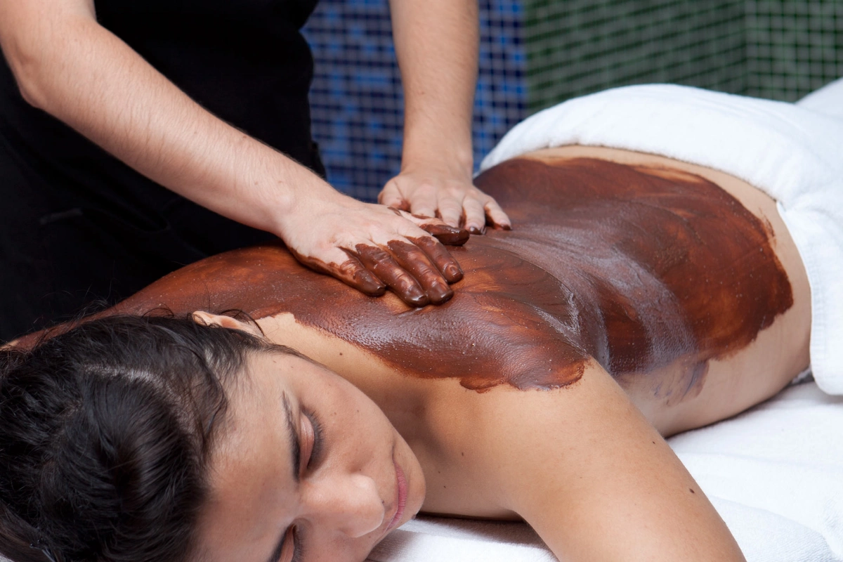 Mujer recibiendo un masaje con chocolate en la espalda.
