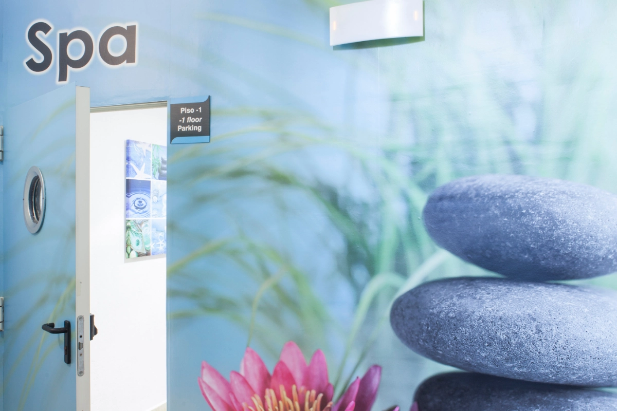 Puerta de spa abierta con piedras apiladas y un letrero de estacionamiento.