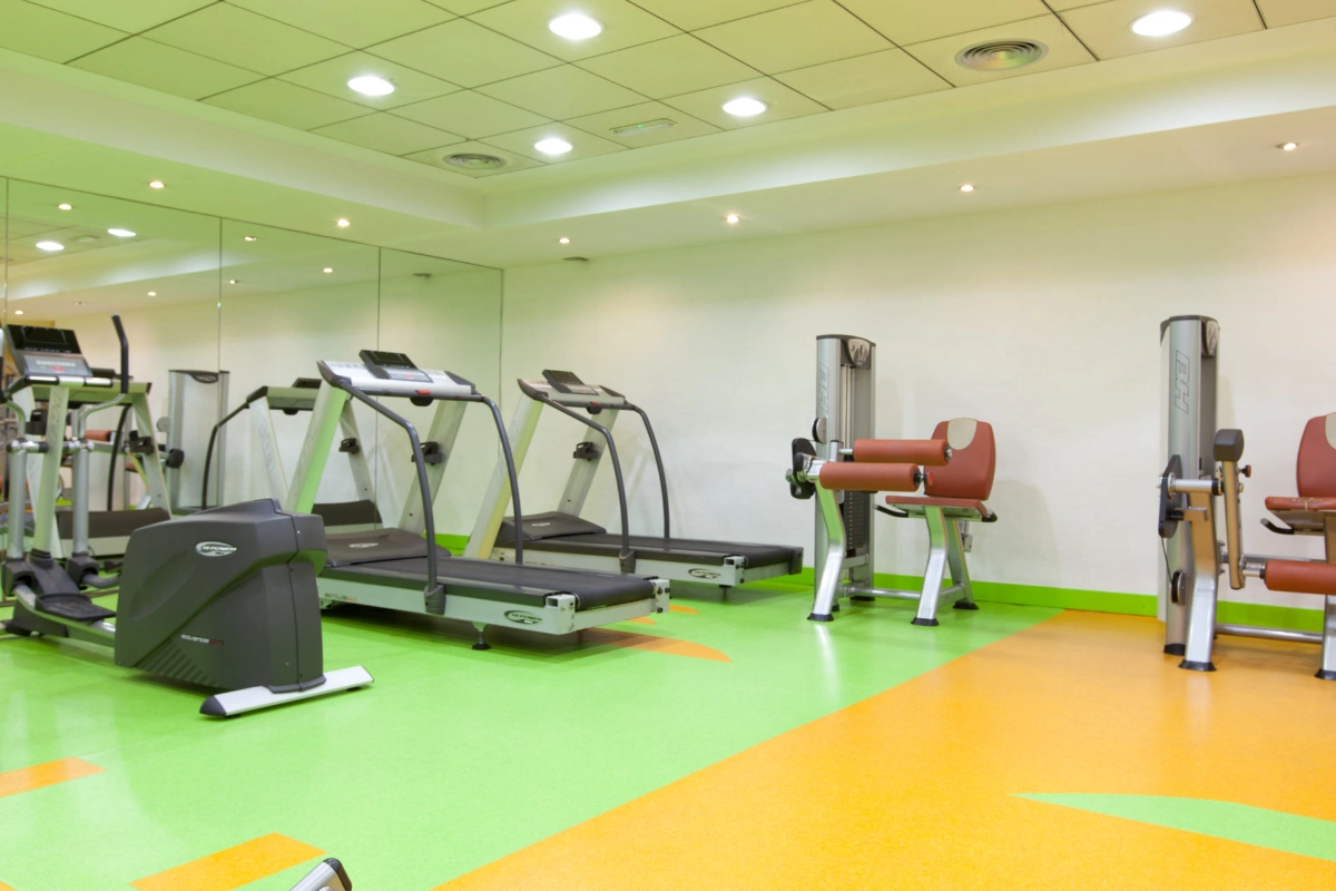 Gimnasio vac&iacute;o con cintas de correr y m&aacute;quinas de ejercicio.