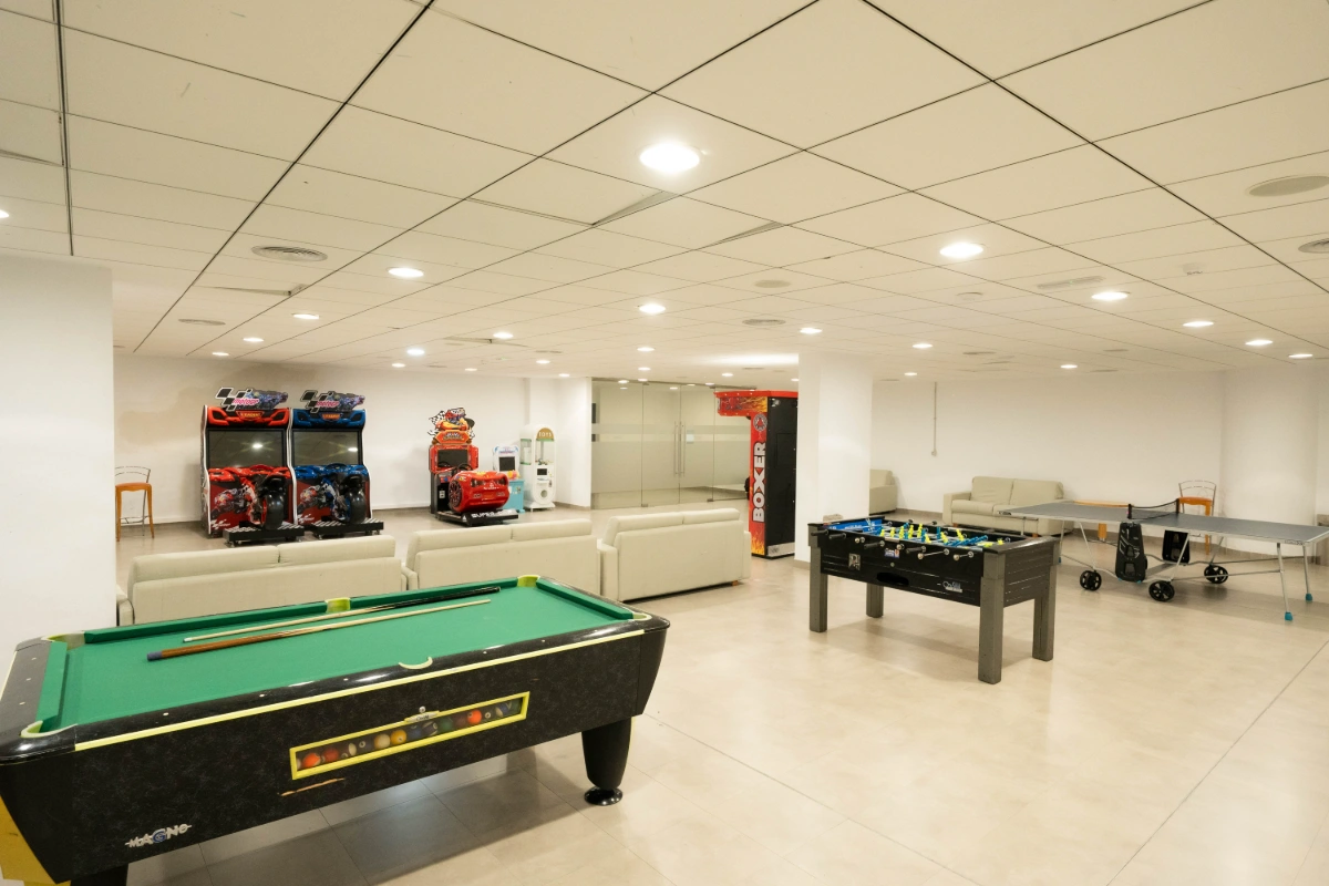 Sala de juegos con billar, futbol&iacute;n y m&aacute;quinas recreativas.