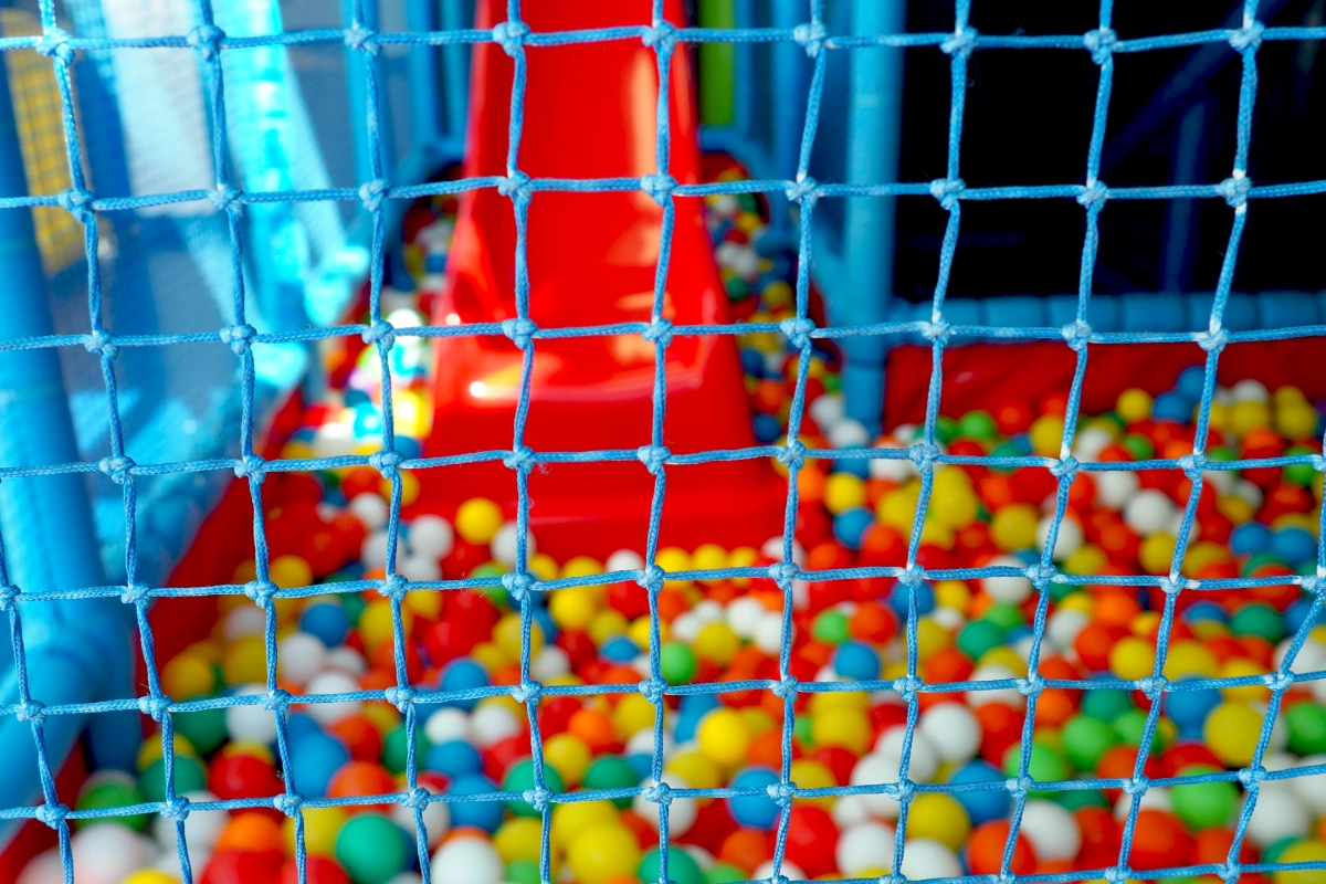 Red y piscina de pelotas de colores en un &aacute;rea de juegos infantiles.