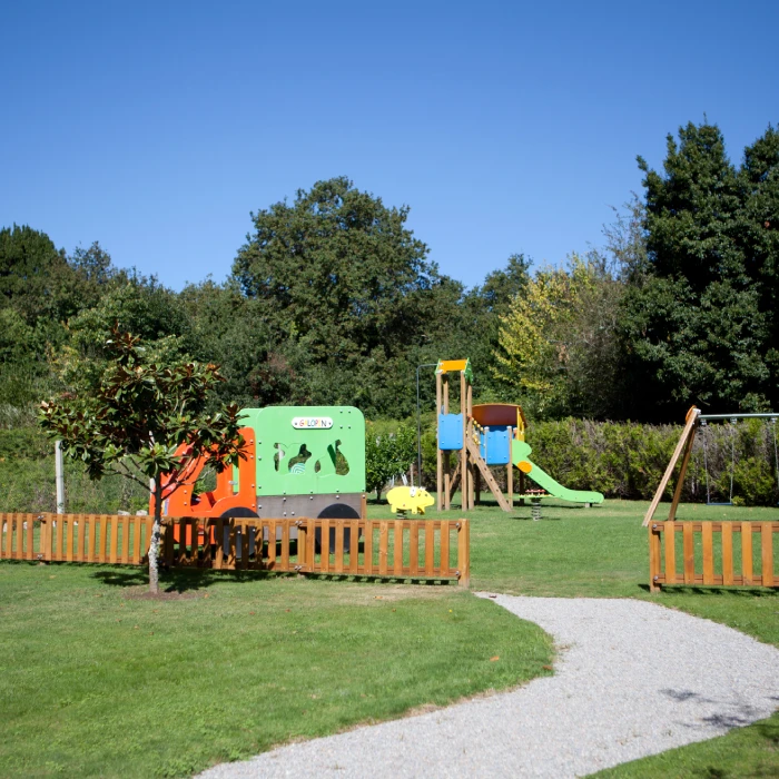 &Aacute;rea de juegos en un parque con estructuras coloridas y cielo despejado.