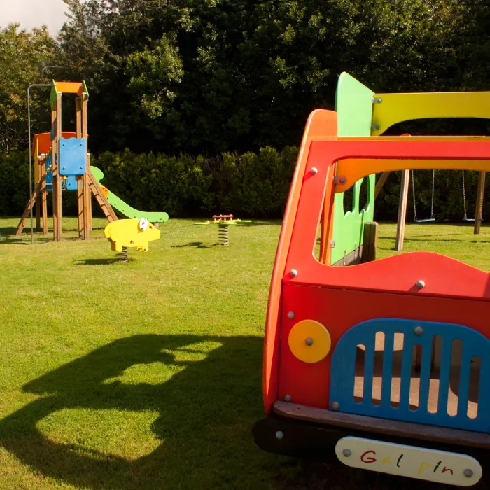 Zona de juegos infantil al aire libre con tobog&aacute;n y estructuras coloridas.