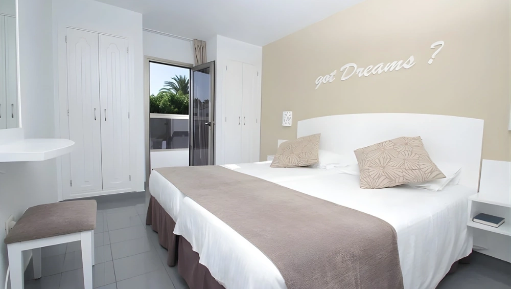 Dormitorio moderno con cama doble y decoraci&oacute;n sencilla.