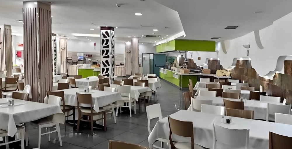 Restaurante moderno con mesas vestidas y sillas marrones y blancas.