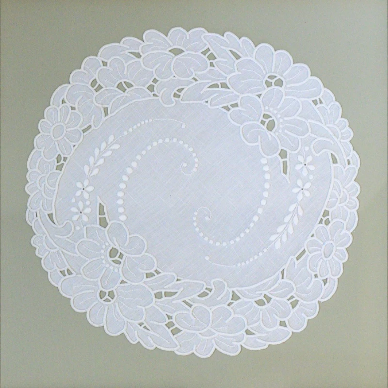 A round white lace doily with floral patterns.