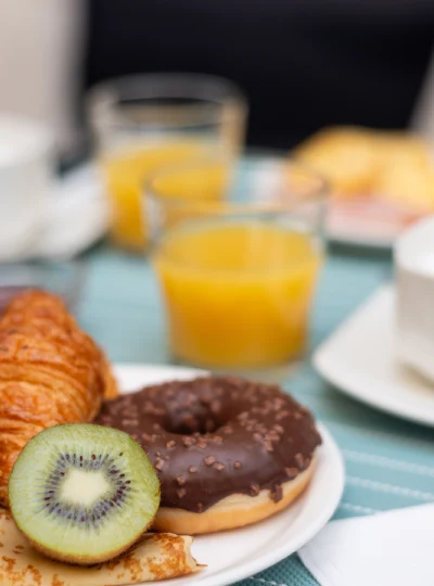 Donuts au chocolat et kiwi, avec jus d&rsquo;orange au petit-d&eacute;jeuner.