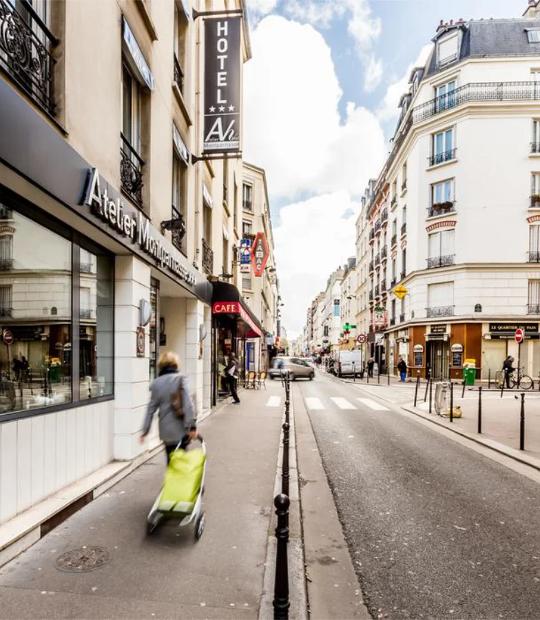 Rue parisienne anim&eacute;e avec passant et commerces.