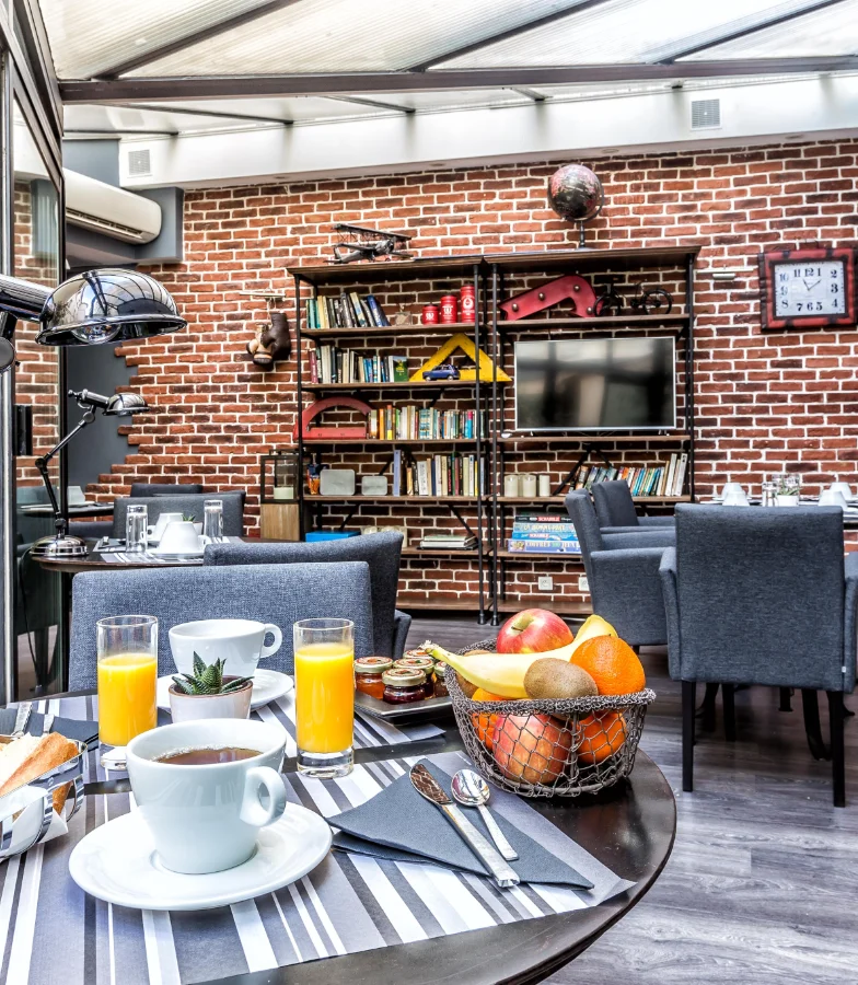 Petit-d&eacute;jeuner servi dans une salle &agrave; manger moderne avec mur en briques.