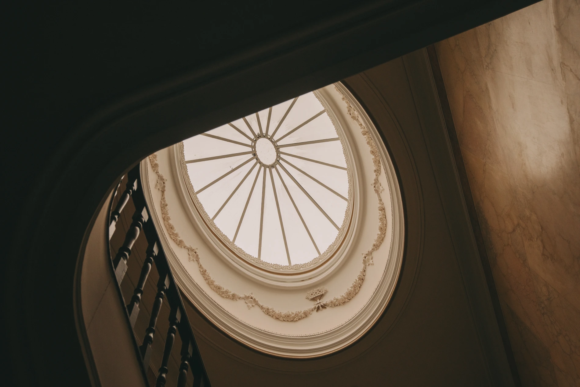 Ornate skylight viewed through a grand staircase.