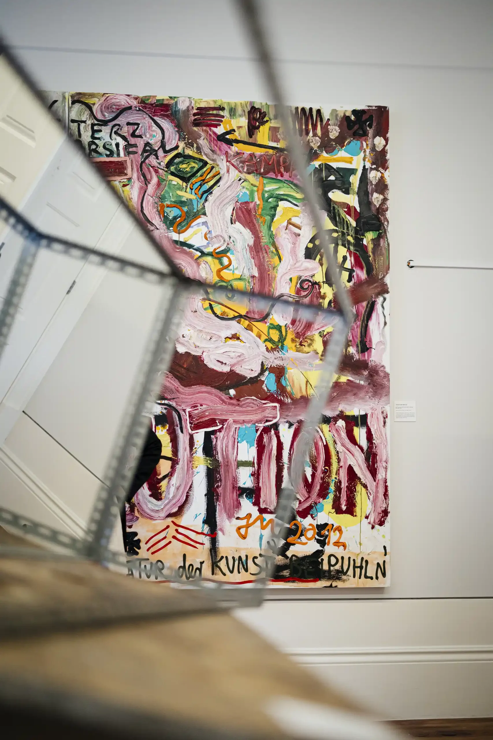 Abstract painting with colorful brushstrokes and text on canvas.