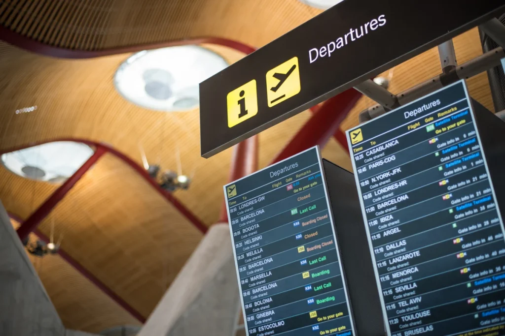 Pantalla de vuelos de salida en un aeropuerto, techo moderno de madera.