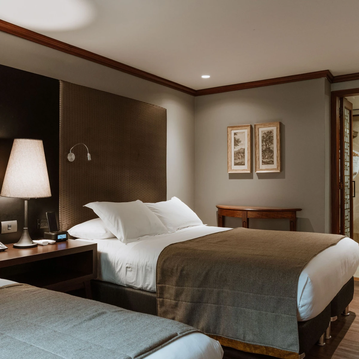 Cama bien arreglada en una habitaci&oacute;n de hotel elegante y acogedora.