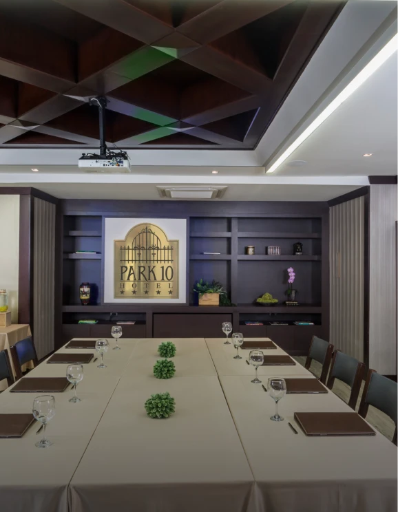 Sala de reuniones en hotel con mesa larga y decoraci&oacute;n elegante.