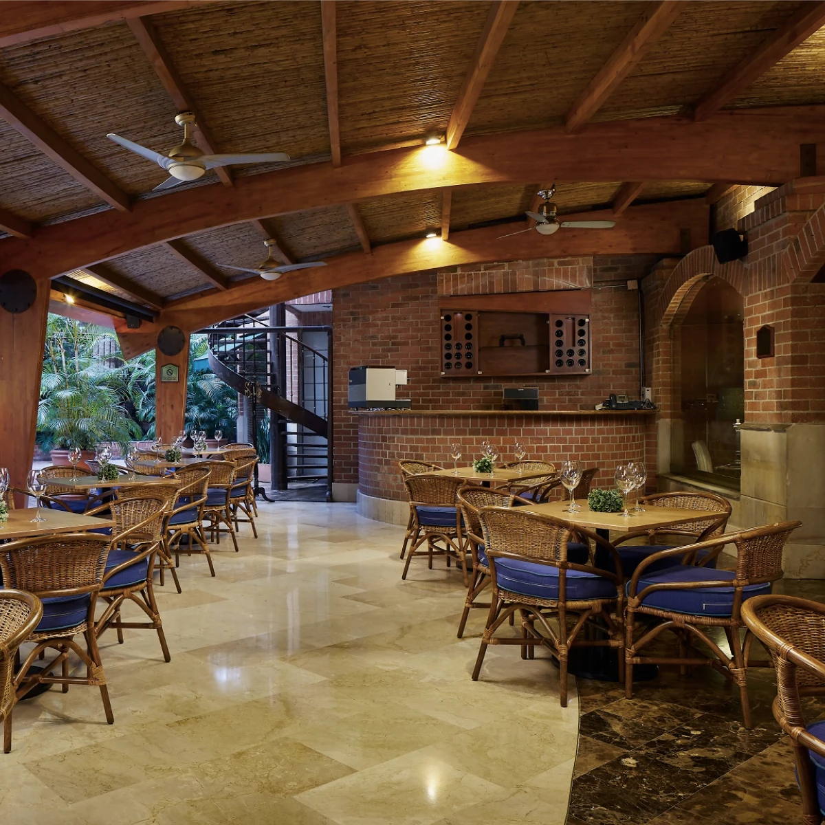 Restaurante elegante con techo de madera y sillas de mimbre.