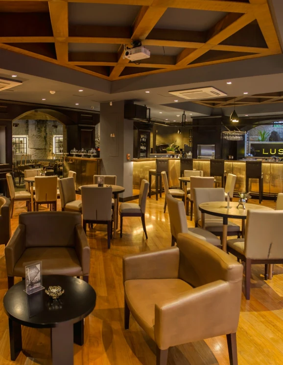 Sala moderna de restaurante con mesas y sillas de cuero marr&oacute;n.