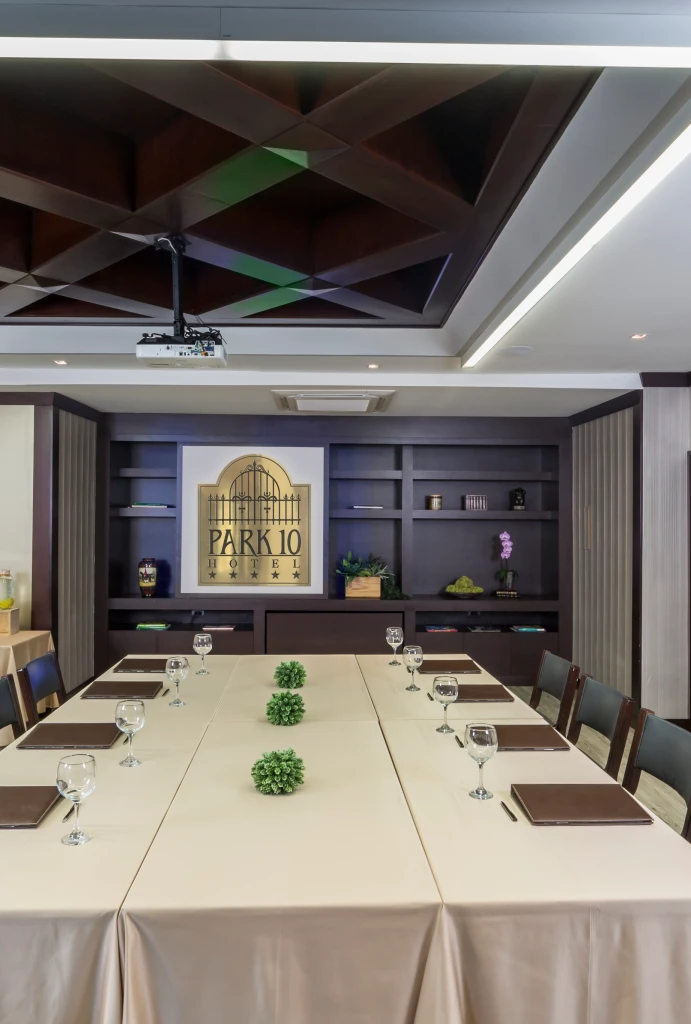 Sala de conferencias con mesa, copas y carpetas en hotel Park 10.