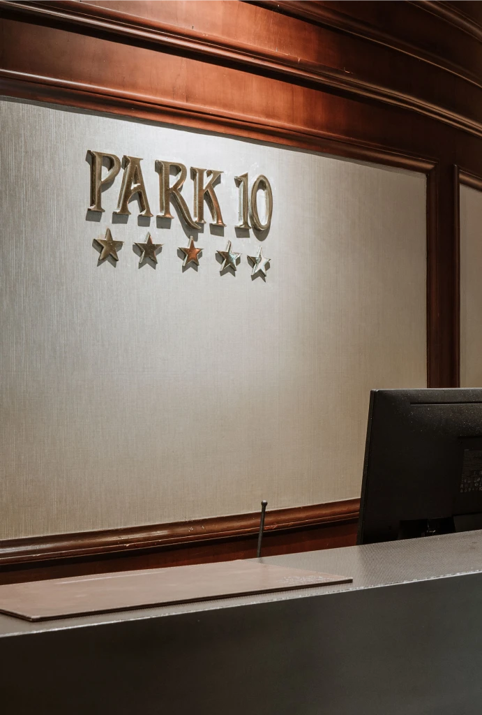 Mostrador de recepci&oacute;n con el cartel "Park 10" y cinco estrellas en la pared.